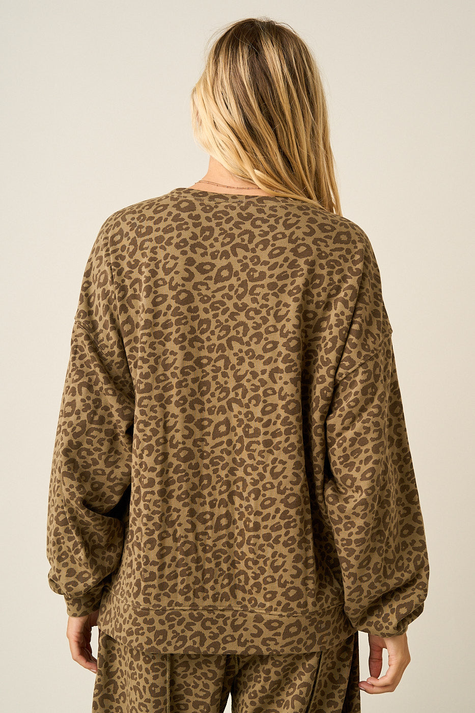 Back of women wearing a leopard print oversized sweatshirt and matching pants.