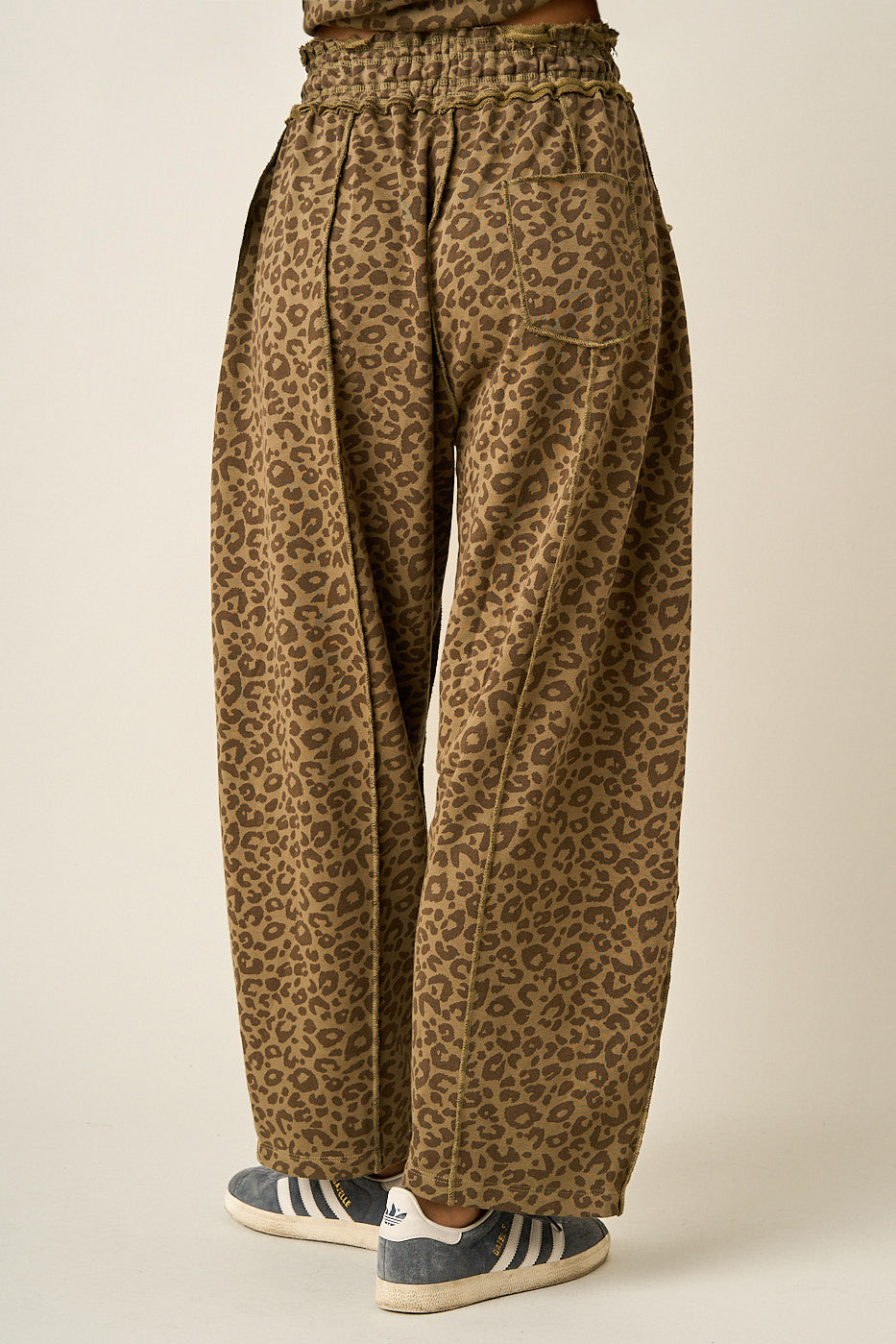 Back of women wearing leopard print barrel pants.