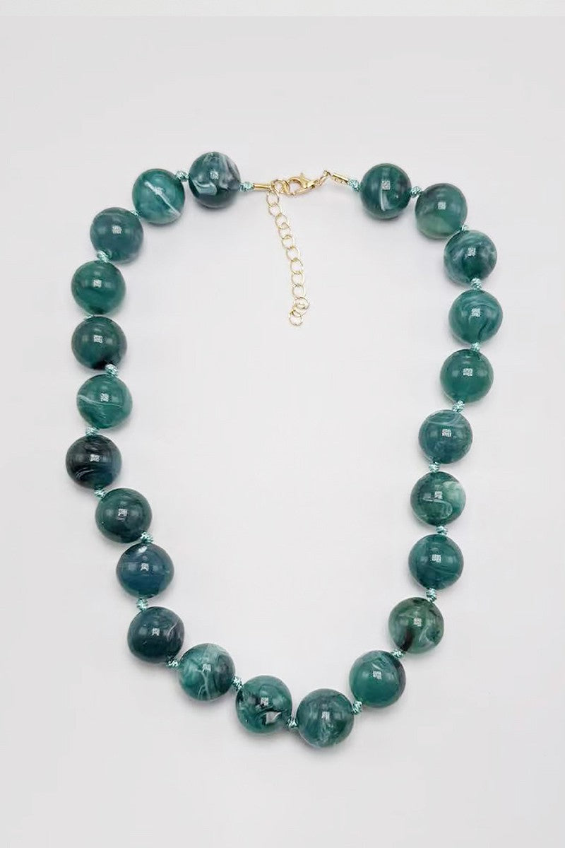 Teal - cyan blue beaded necklace on a white background