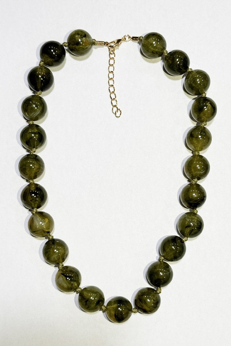 Necklace with army green beads on a white background