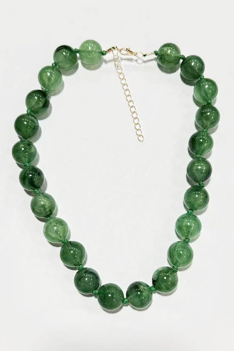 Green beaded necklace on a white background