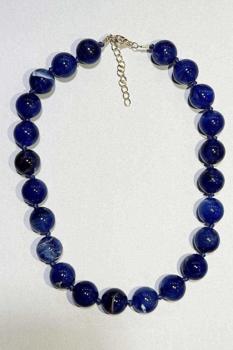 Necklace with blue beads on a white background