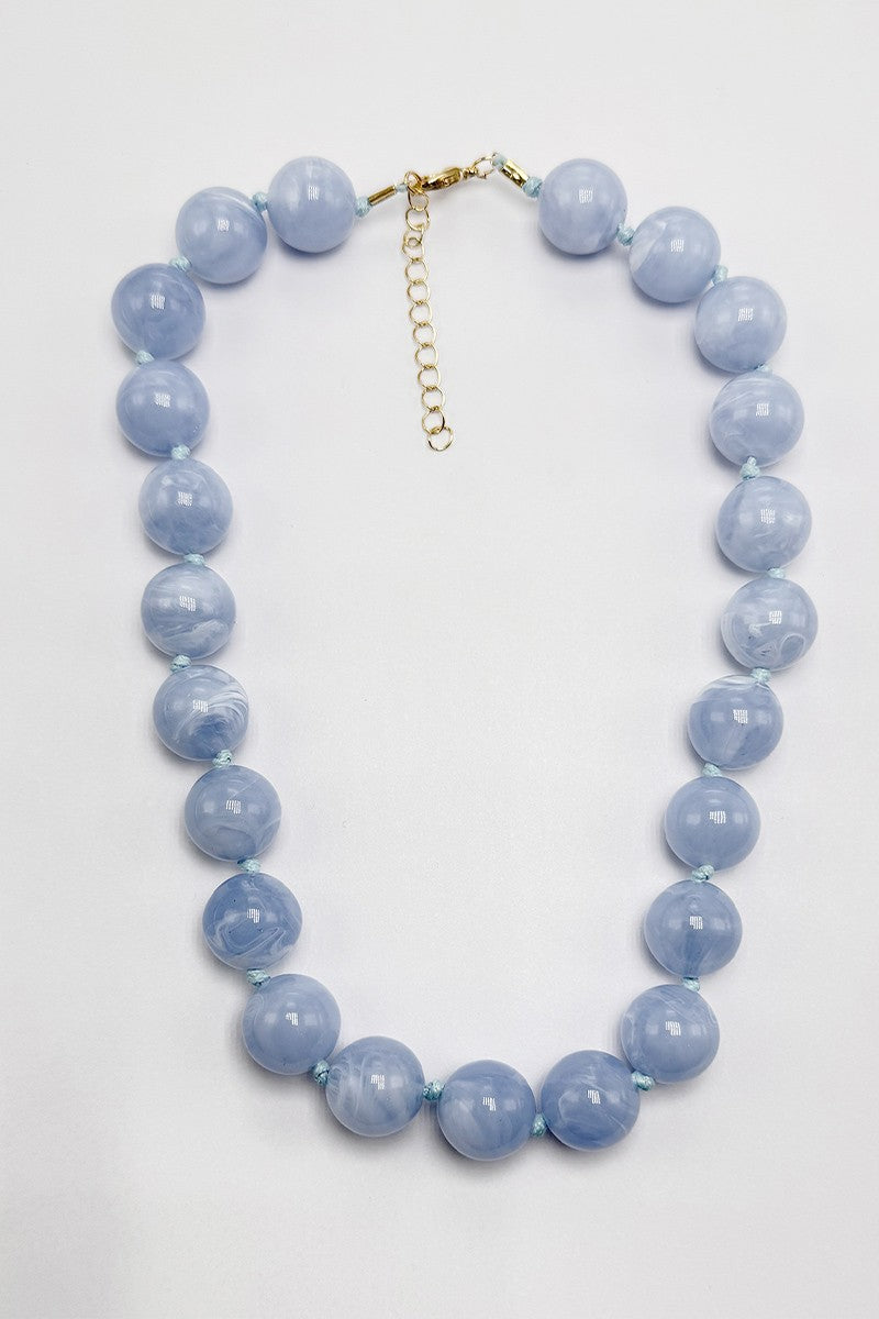Necklace with light sky blue beads on a white background