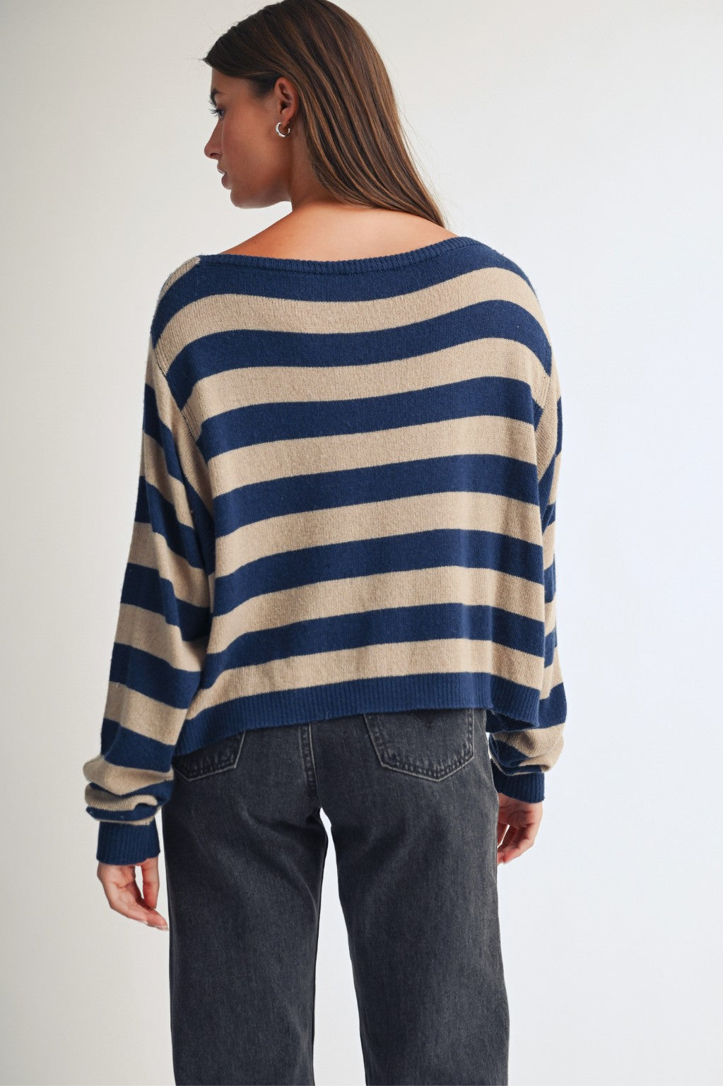Back of a women in a stripe boat neck sweater with jeans.
