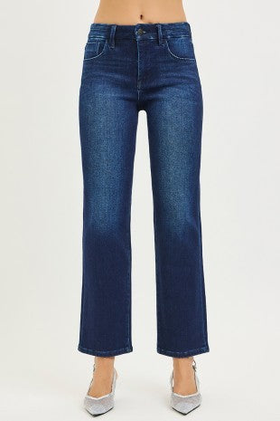 A person wearing dark blue straight-leg denim jeans with silver pointed-toe heels, shown from the waist down against a plain light background.