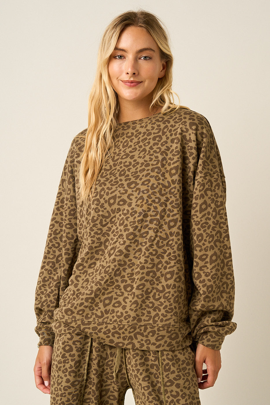 Women wearing a leopard print oversized sweatshirt and matching pants.
