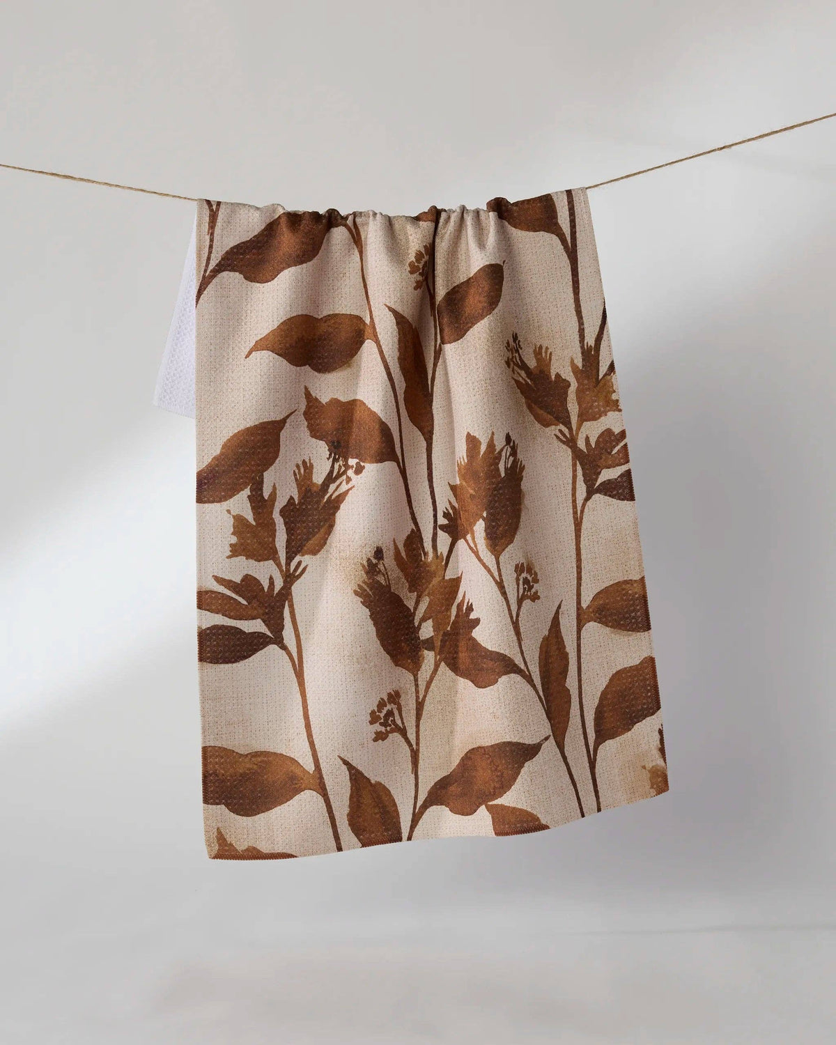 Fall foliage printed tea towel on a white background.