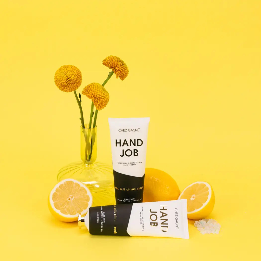 Hand cream with packaging labeled 'HAND JOB' on a yellow background with lemons and flowers.