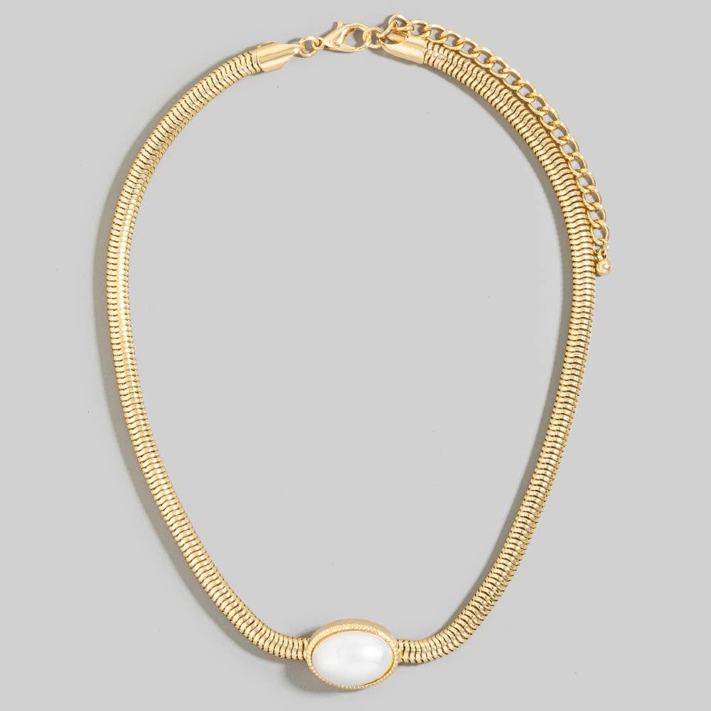 Gold necklace with a white stone on a gray background