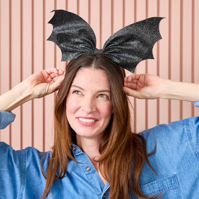 Women wearing a bat novelty headband.